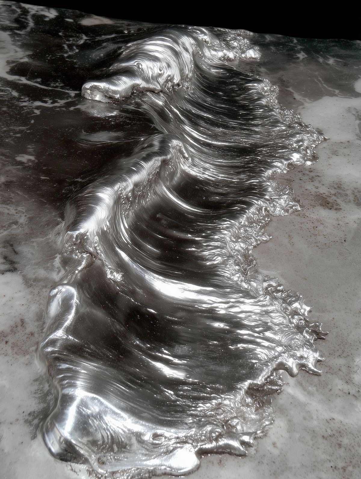 Liquid silver flowing across dark stone